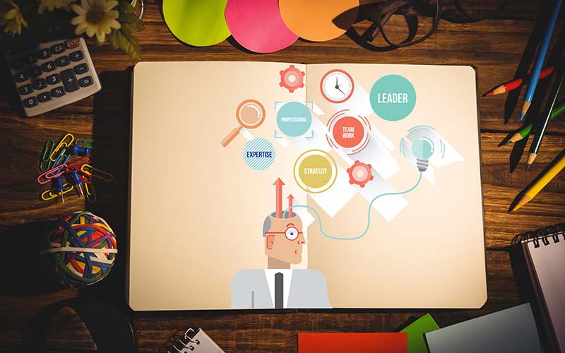 A man sitting at a desk with a laptop and pen, engrossed in work