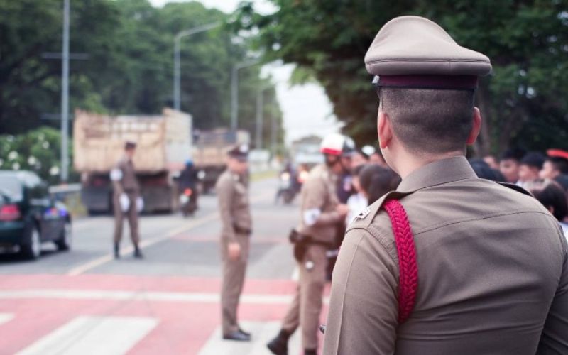 A police officer in uniform stands in the middle of a street, maintaining order and ensuring safety